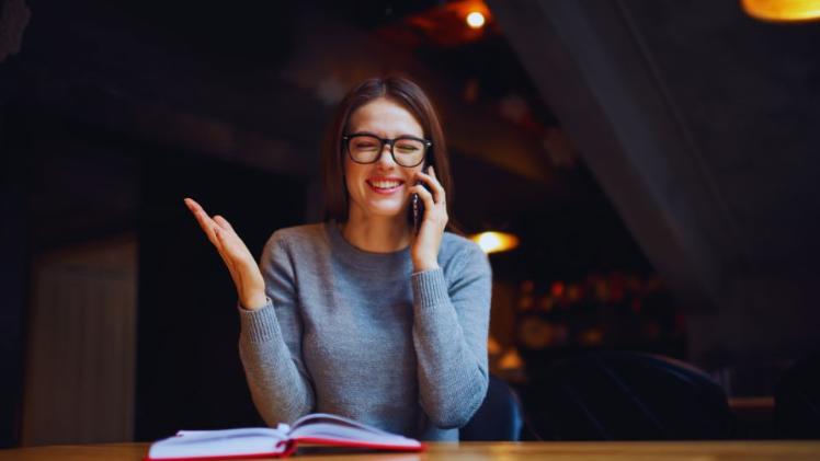 woman sitting at a table with a book open